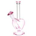 A pink heart-shaped glass bong water pipe with a matching bowl