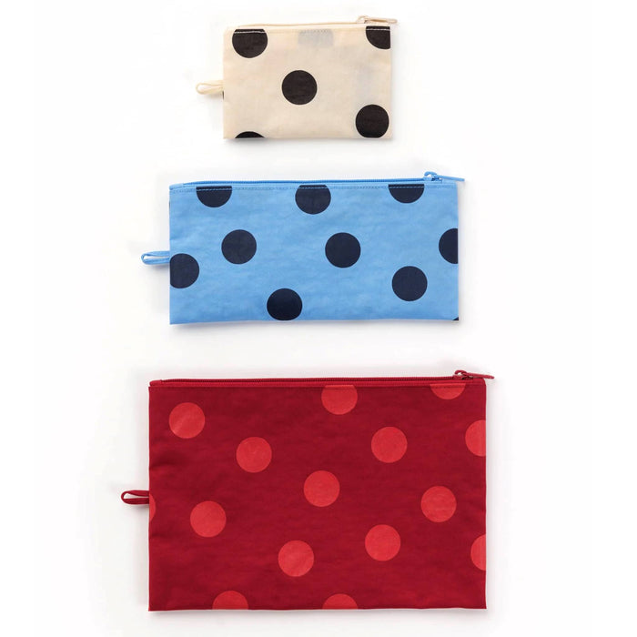 Three fabric zip pouches with polka dot patterns stacked vertically on a white background. The top pouch is cream with black dots, the middle is light blue with black dots, and the bottom is red with larger red dots.