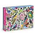 The Birdhouse Lane 1000 Piece Puzzle by Christine De Carvalho showcases colorful birds and decorative birdhouses with flowers on a cream background. The box features pink and blue sides.