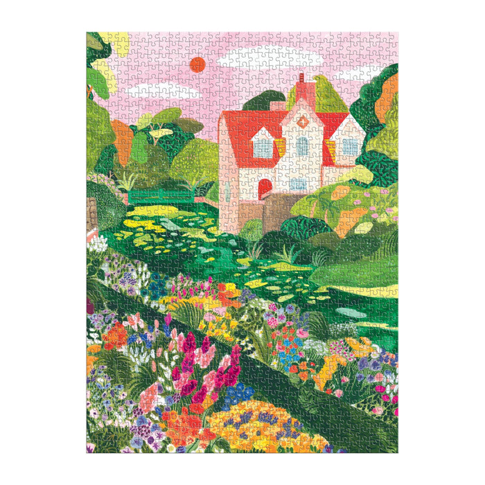 The Blooming Meadow 1000 Piece Puzzle by Flore Cousseran features a charming house with a red roof, lush greenery, blooming flowers, and a lily pad pond beneath a pink sky.