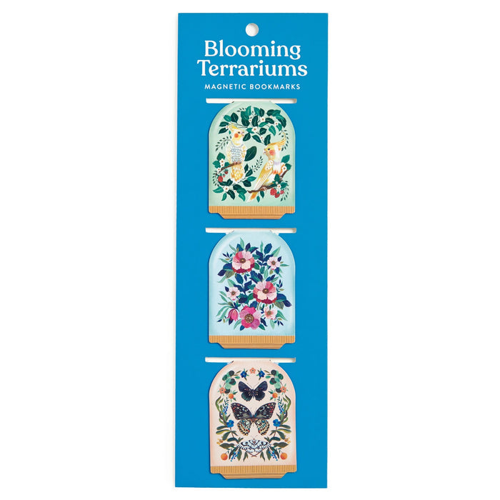 The Christine De Carvalho Blooming Terrariums Magnetic Bookmarks set features three bookmarks with illustrated designs: a bird among flowers, a bouquet of flowers, and two butterflies with flowers in a blue package.