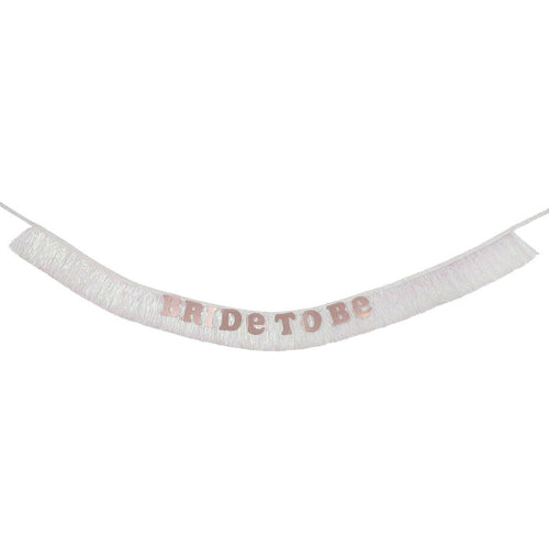 An iridescent white fringe sash with the words 'BRIDE TO BE' in shiny rose gold letters, suspended against a plain white background.
