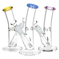 Three glass bongs with colored tops on a white background