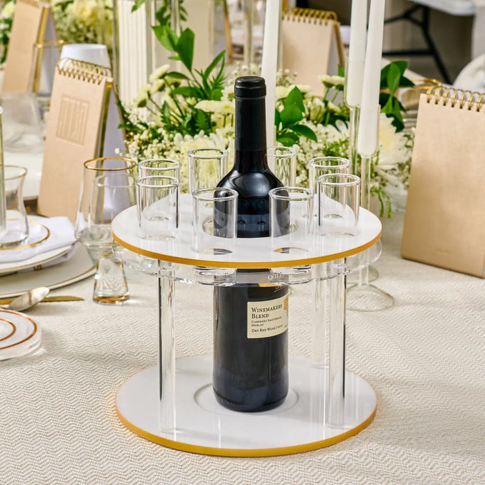 Classic round liquor set with marble top, brass accents, and black bottle holder displayed on white table with place settings.