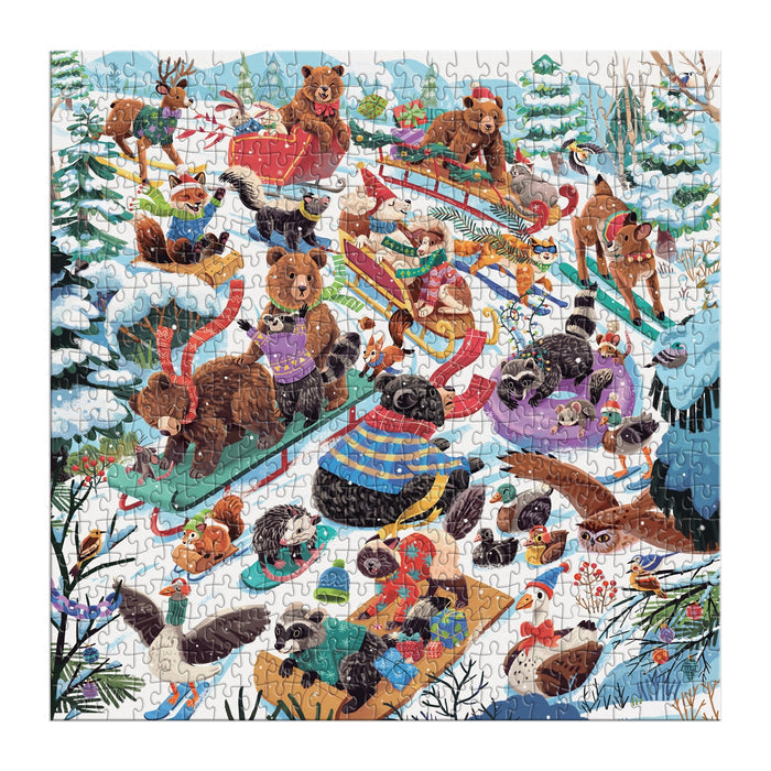 The Dashing All the Way 500 Piece Puzzle by Lucia Baertl features animals like bears, raccoons, otters, and birds sledding and playing in a snowy forest winter scene with trees and snow-covered hills.