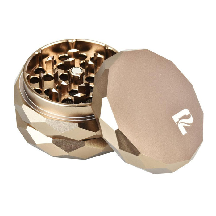 Bronze metallic grinder with geometric design on a white background