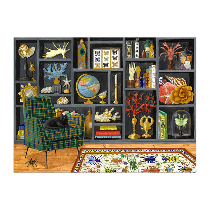 A cozy room with a plaid armchair, black cat, colorful rug, and a bookshelf filled with Mélanie Voituriez’s Eclectic Treasures 1000 Piece Foil Puzzle artwork, globes, coral, antlers, butterfly displays, jars, curiosities—and a spider on the floor.