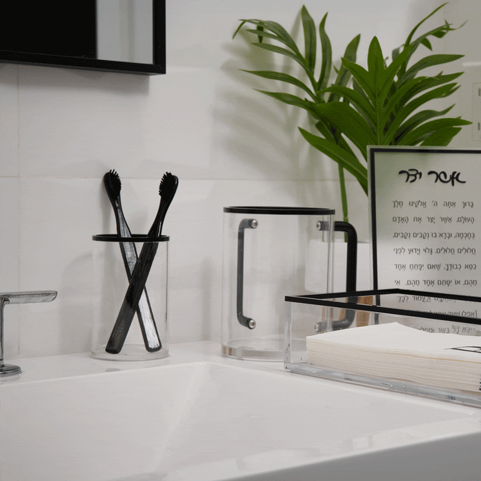 Black stainless steel Edge Cup displayed on white bathroom vanity next to toothbrushes and plants