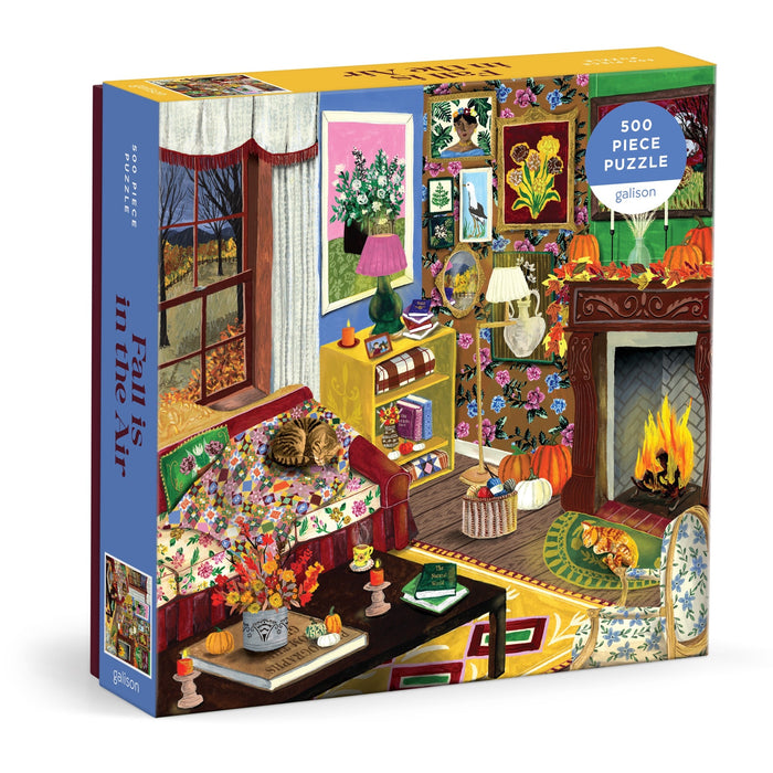 Enjoy a cozy afternoon with the "Fall is in the Air 500 Piece Puzzle" by Abby Jacobs. This beautifully illustrated puzzle features a vibrant autumn living room scene complete with cats, a glowing fireplace, pumpkins, colorful artwork, and fresh flowers. With detailed fall decor and a warm, inviting atmosphere, it’s the perfect rainy day activity for anyone who loves autumn.