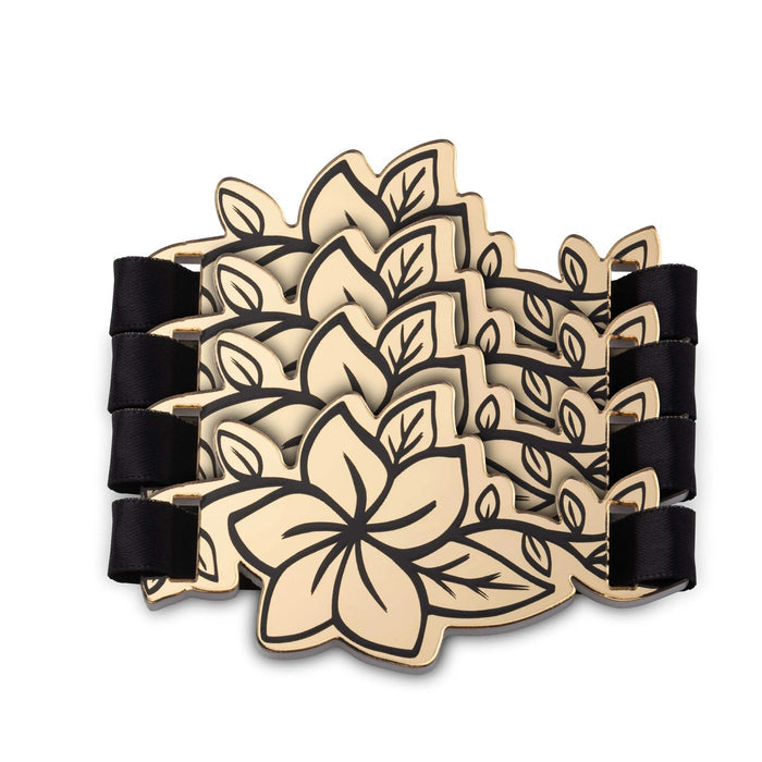 Gold floral napkin rings with black enamel accents, featuring layered petal design for elegant table settings.