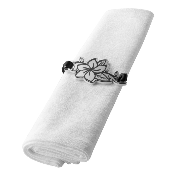 White linen napkin secured with silver floral napkin wrap ring featuring ornate metal design detail.