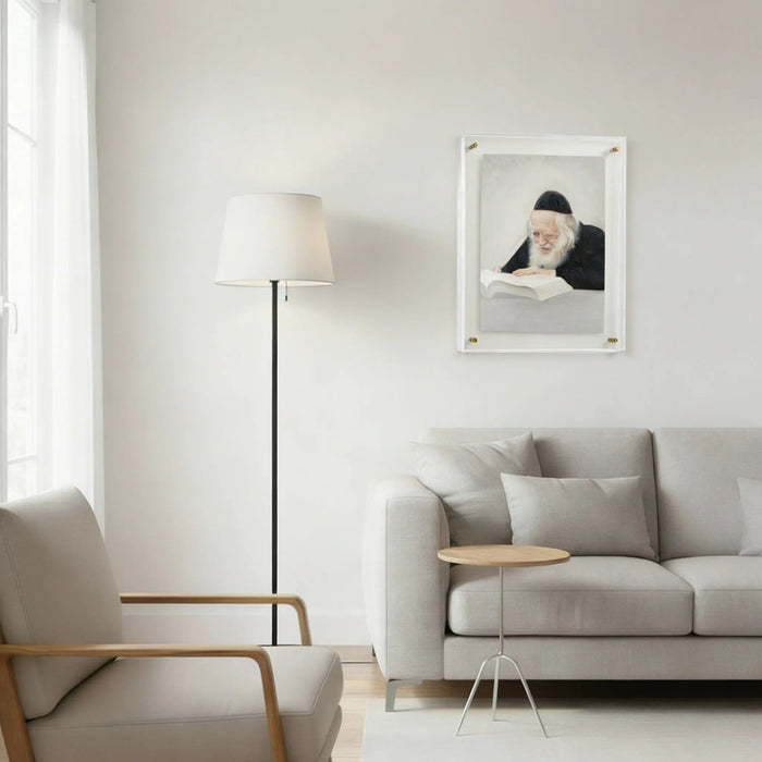Framed portrait of Rav Chaim Kanievsky in light marble finish, displayed above beige sofa in modern living room setting.