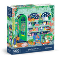 The Good Puzzle Co. Bookshop Cats 500pc Puzzle by Lee Foster-Wilson features cats in a vibrant bookshop scene with bookshelves, a stroller, doorstep, tree, and plants—an eco-friendly treat for cat lovers and bookworms.