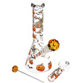 Clear glass water pipe with Halloween-themed printed designs of pumpkins, bats, and skeletons, featuring an amber glass bowl and accessories on a white background.