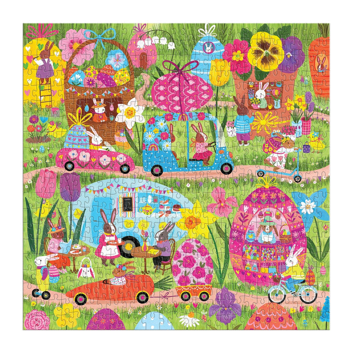 The Hoppin' Around 500 Piece Family Puzzle by Jenny Miriam features whimsical bunnies in egg-shaped houses, driving cars and bikes among giant flowers and eggs—a colorful family puzzle ideal for all ages.