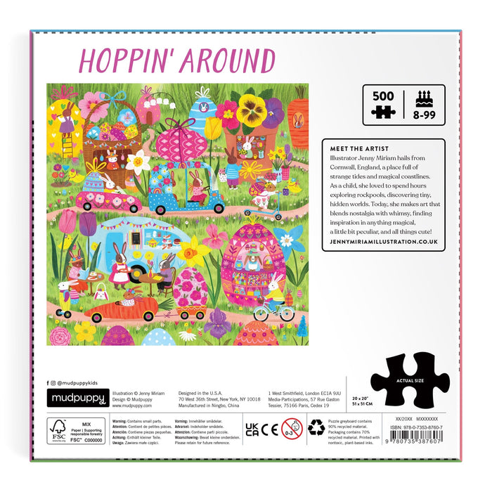 Lively outdoor scene with animals, flowers, and decorated eggs. The Hoppin' Around 500 Piece Family Puzzle by Jenny Miriam is perfect for ages 8–99. Artist bio and social links are included on the box side.