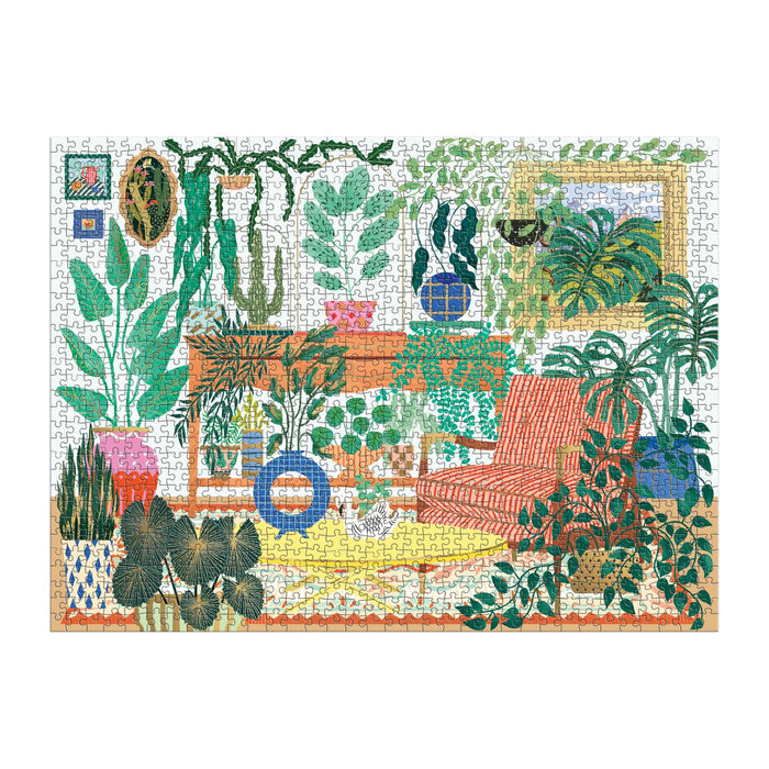 The Houseplant Haven 1000 Piece Foil Puzzle by Faye Guanipa features a cozy indoor scene with lush greenery, a red striped armchair, potted plants on a wooden table, framed art, and a yellow patterned rug.