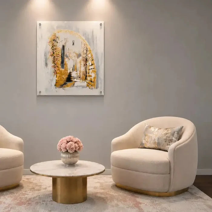Jerusalem Alleyways watercolor painting displayed above a cream armchair, featuring warm golden tones in a modern living room setting.