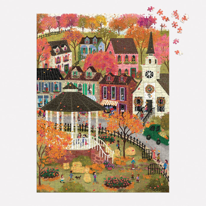 The Joy Laforme Falls Hollow 1000 Piece Puzzle by Joy Laforme showcases a vibrant autumn village with a gazebo, playful children, houses, a steepled church, orange-leaved trees, and missing pieces in the top right corner.