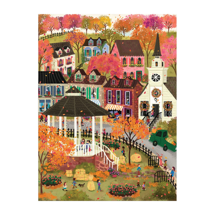 The Joy Laforme Falls Hollow 1000 Piece Puzzle by Joy Laforme features a lively autumn village with people near a white gazebo, colorful houses, a tall-steepled church, pumpkins, hay bales, and trees in vibrant orange and pink.