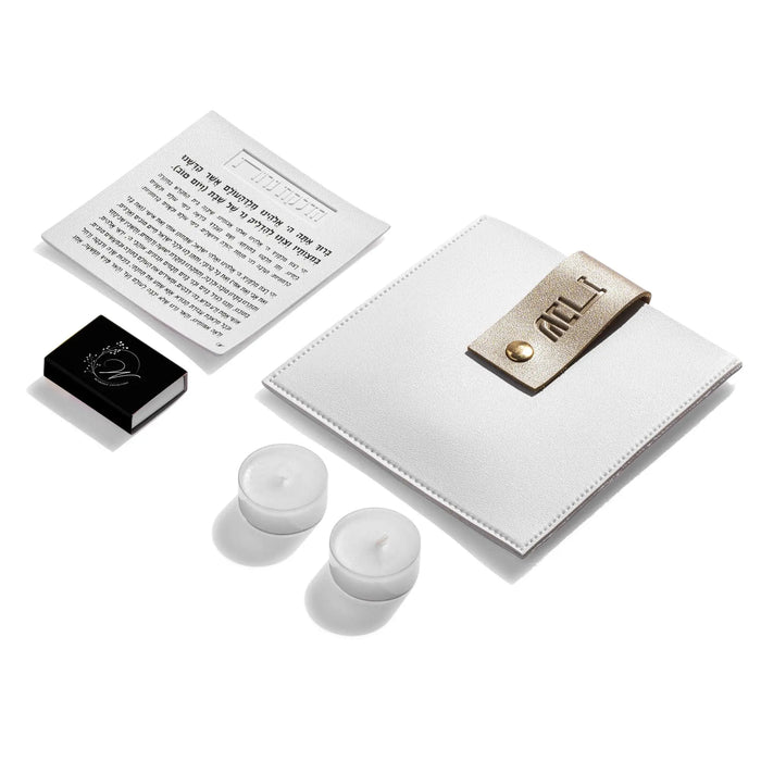 White leather Hadlokas Neiros pouch by Waterdale Collection displayed with instruction card, candles, and lucite case for holiday candle lighting.