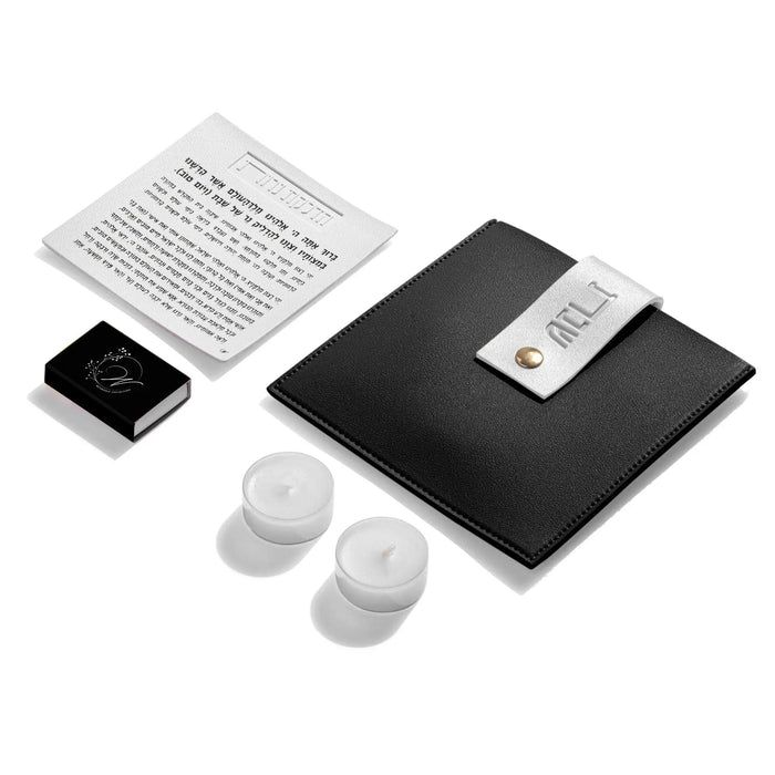 Black leather Hadlokas Neiros pouch with lucite candle-lighting cards and white holders displayed on white background