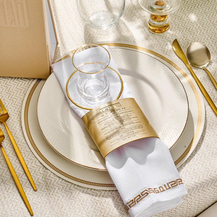 Leather herringbone pesach round charger in silver displayed on a formal place setting with white napkin and gold flatware.