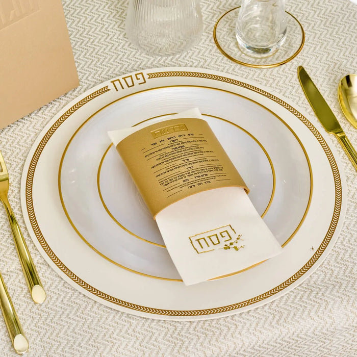 Gold leather herringbone Pesach charger plate displayed with place setting and gold Haggadah on white table.