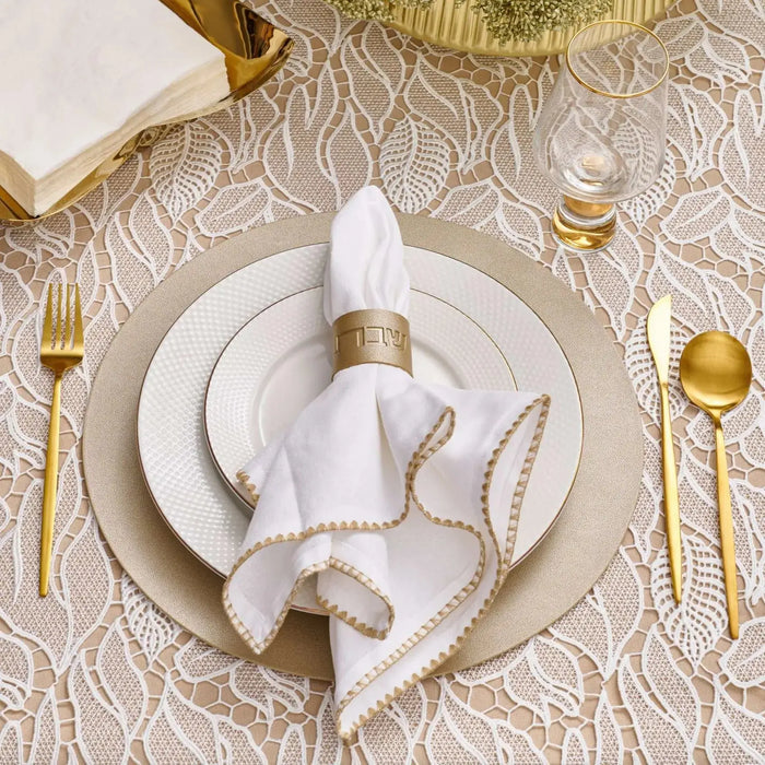 Waterdale Collection leather table settings bundle featuring white napkin rings and holder on place settings with gold flatware and beige textured tablecloth.