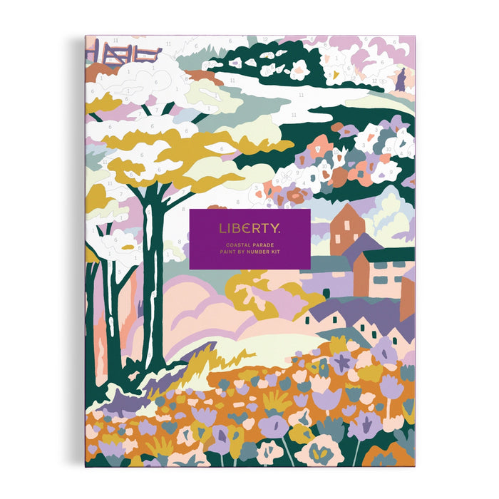 The Liberty London Coastal Parade 9 x 12" Paint by Number Kit features a vibrant landscape with trees, flowers, houses, and a barn. A central purple label displays the product name.