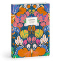 The Liberty London Glastonbury Premium A5 Notebook features a vibrant floral cover in orange, blue, pink, and green with a front white Liberty label and includes 300 pages.