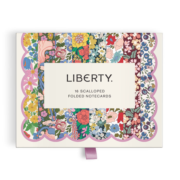 The Liberty Premium Notecard Set by Liberty London features 16 scalloped folded cards with multicolored floral patterns and a lavender ribbon pull tab. A white label with LIBERTY. is centered on the box.