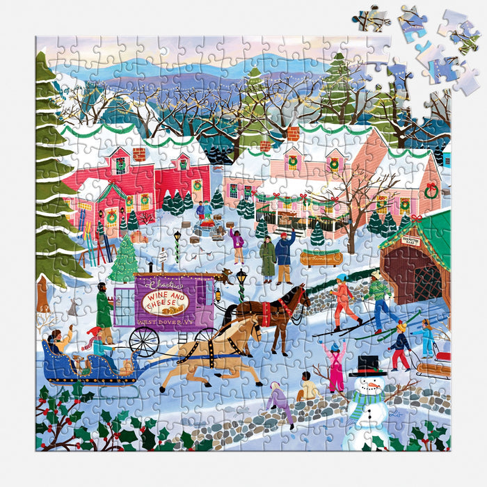 The Little Winter Town 300 Piece Puzzle by Elisabeth Dorrian features a vibrant winter scene with people ice skating, sledding, making a snowman, and sleigh rides among festive houses. Four pieces remain to be placed.