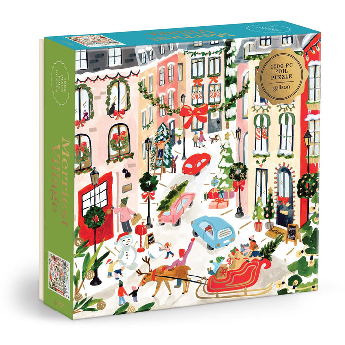 The Sabina Fenn Merriest Village 1000 Piece Foil Puzzle showcases a vibrant, snowy village street at Christmas, with people, cars, a sleigh, decorated trees, and festive garlands in a cheerful winter scene.