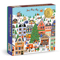 The Holly Maguire Merryville 500 Piece Foil Puzzle features a festive winter village with decorated houses, people ice skating and building snowmen, plus Santa flying overhead.