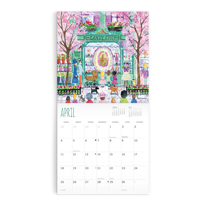 The Michael Storrings 12 x 12 Wall Calendar 2027 features a vibrant April candy shop scene with people, pink blooming trees, and sweets outside; the calendar grid appears beneath the illustration. Brand: Michael Storrings.