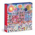 The Michael Storrings Celebrate The USA 500 Piece Foil Puzzle features a festive parade with flags, decorated houses, and fireworks, honoring America’s 250th anniversary (1776–2026).