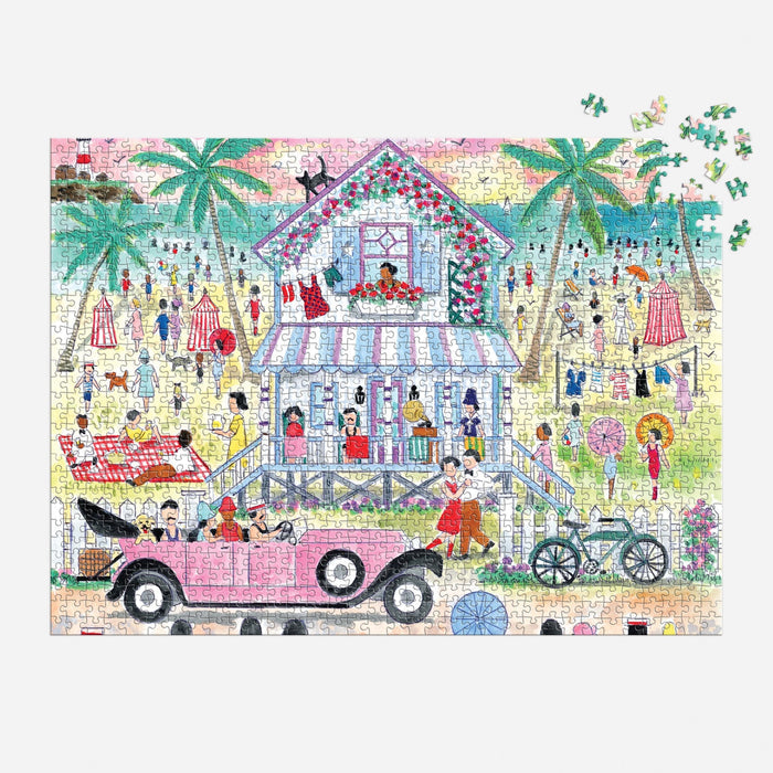The Michael Storrings Roaring 20s Beach House 1000 Piece Puzzle by Michael Storrings features a vibrant beach scene with people, palm trees, a stilted seaside house, and a vintage pink car. Some puzzle pieces remain unplaced in the top right corner.
