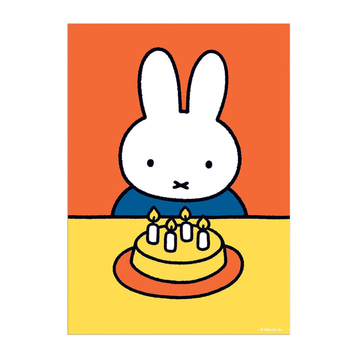 The Miffy Birthday Greeting Card Puzzle by Miffy features a white cartoon rabbit with upright ears sitting at a yellow table with a birthday cake and five lit candles, set against an orange background in a simple, colorful style.