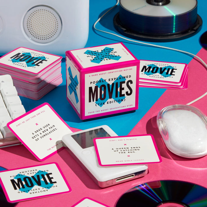 A box labeled Mini Poorly Explained Movies – Y2K Edition by Brass Monkey sits among clue cards, a computer mouse, CDs, and retro tech on a pink and blue background—ideal for your next pop culture trivia game night.