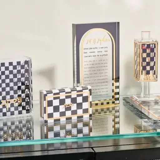 Onyx Hadlokas Neiros block with black and white checkered pattern displayed on glass table with chess set and religious items nearby.
