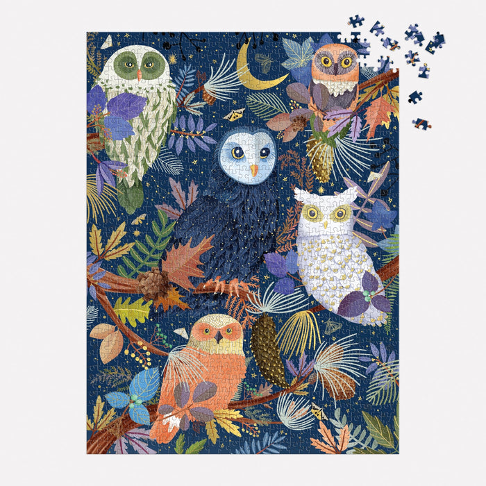 The Owls at Dawn 1000 Piece Foil Puzzle by Mara Penny features five vibrant owls on leafy branches against a dark blue background, with a few pieces unfinished in the top right corner.