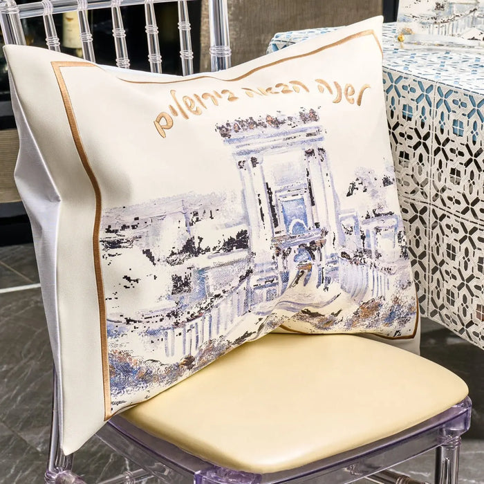 Painted Bais Hamikdash Pesach set with gold and white leather details, displayed on a cream chair with coordinating home decor in background