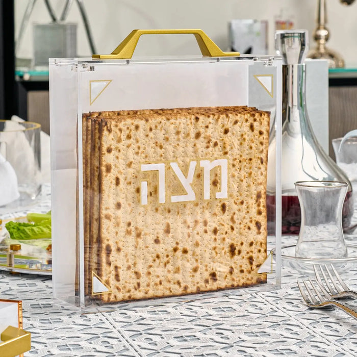 Pearlstone square matzah box with metallic gold accents displayed on kitchen counter with Passover tableware and decorations