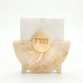 Cream-colored resin Pesach napkin holder with round wooden top featuring Hebrew text, displayed against white background.