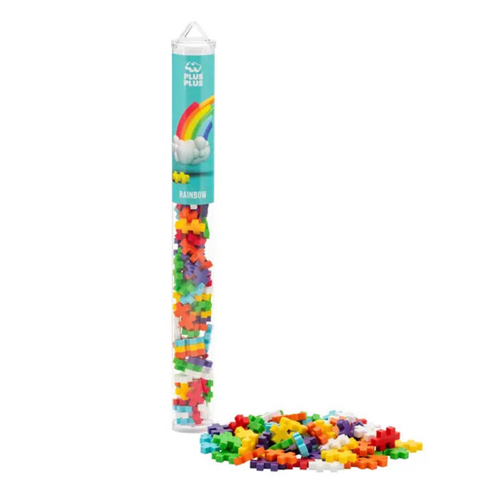 Rainbow plastic building blocks in a clear cylindrical tube with a turquoise label, shown on a white background with some blocks spilled in front.