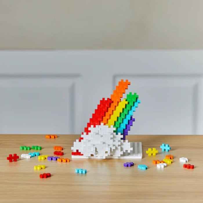 Colorful 3D puzzle of a cloud and a  rainbow on a wooden surface.