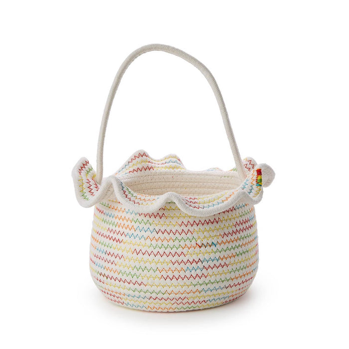 White woven basket with colorful stitching, a ruffle and handle on a white background.