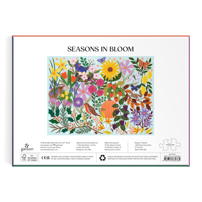 The back of the Lee Foster-Wilson Seasons in Bloom 1000 Piece Puzzle box features a colorful nature illustration with flowers, plants, birds, butterflies, and a pumpkin, plus a white background with text and small icons below the image.