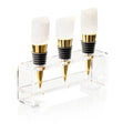Selentine Stone Wine Stoppers by Waterdale Collection featuring three marble and brass stoppers displayed in clear acrylic stand.